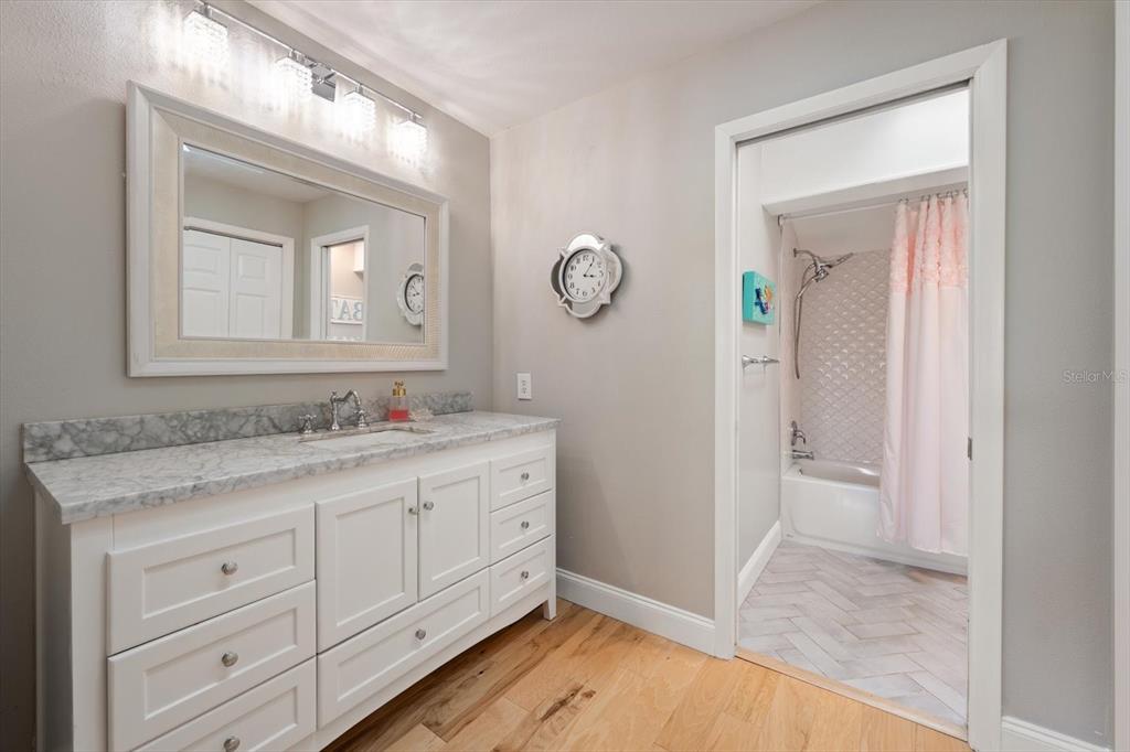2515 Bay Boulevard, Unit B Indian Rocks Beach, FL 33785 - Photo 37 of 66 a bathroom with a granite countertop sink a toilet and a mirror