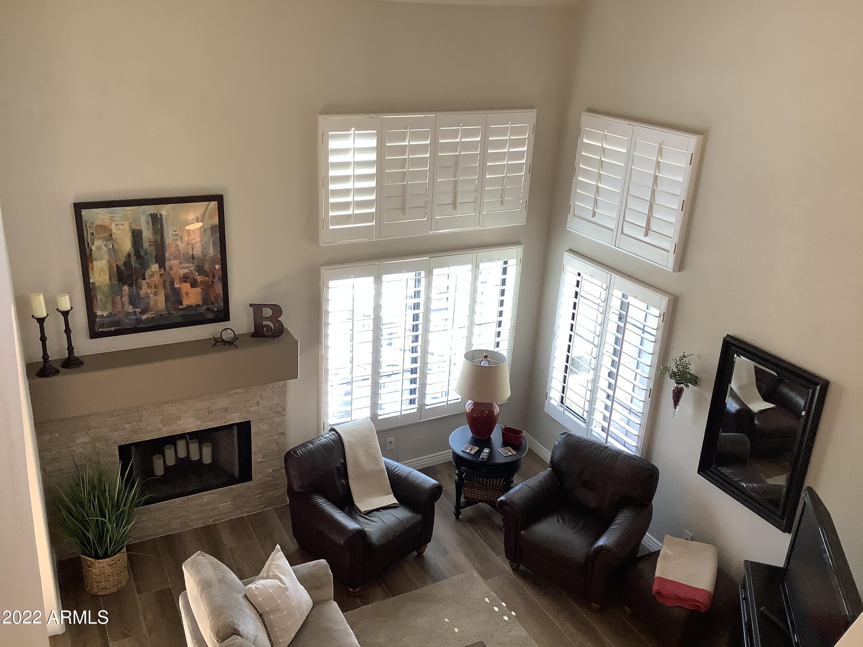 7729 East Joshua Tree Lane Scottsdale, AZ 85250 - Photo 13 of 31 a living room with furniture a flat screen tv and a fireplace