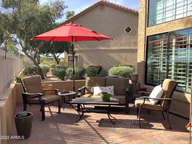 a view of a patio with a table and chairs under an umbrella