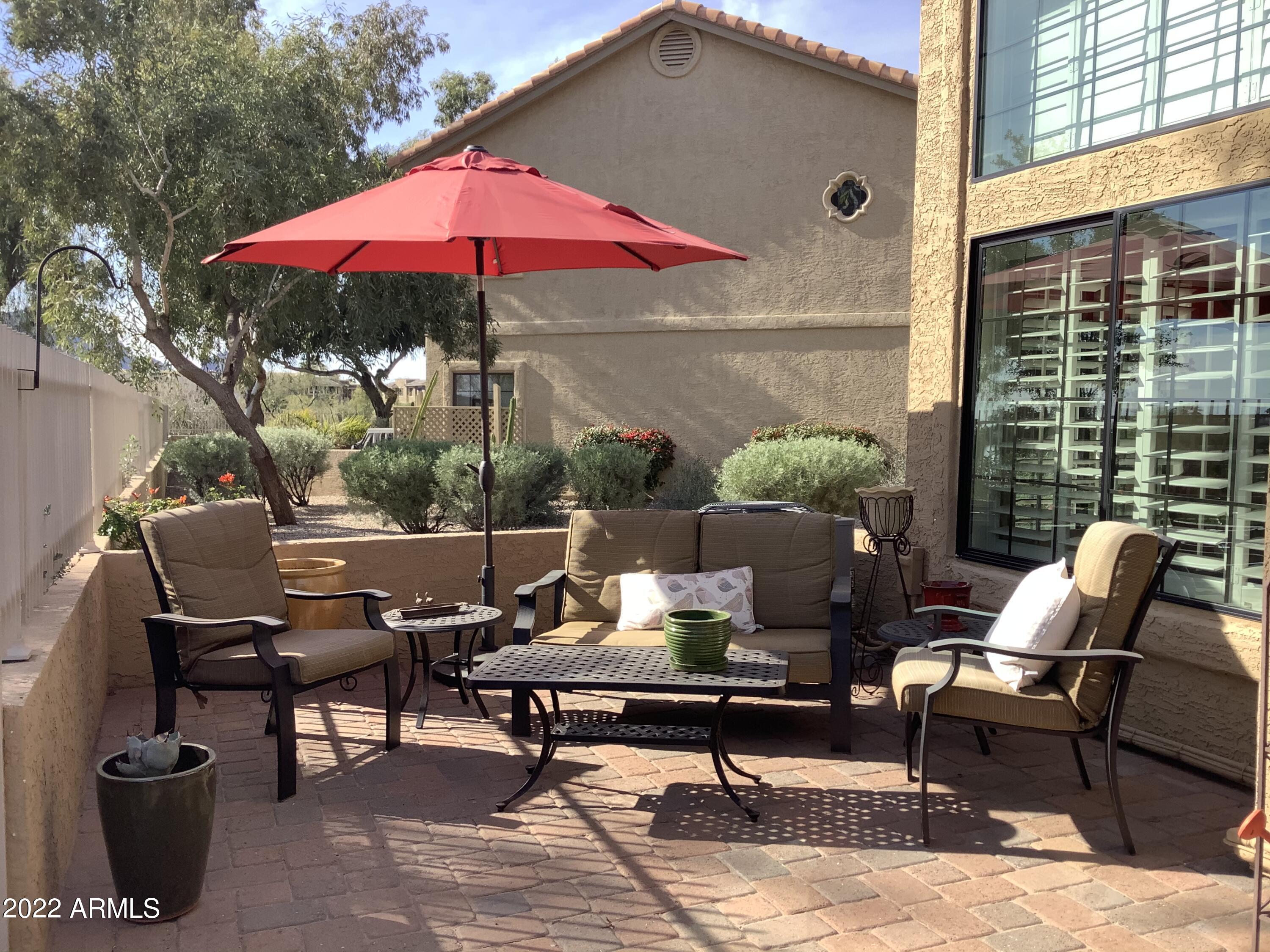 7729 East Joshua Tree Lane Scottsdale, AZ 85250 - Photo 23 of 31 a view of a patio with a table and chairs under an umbrella