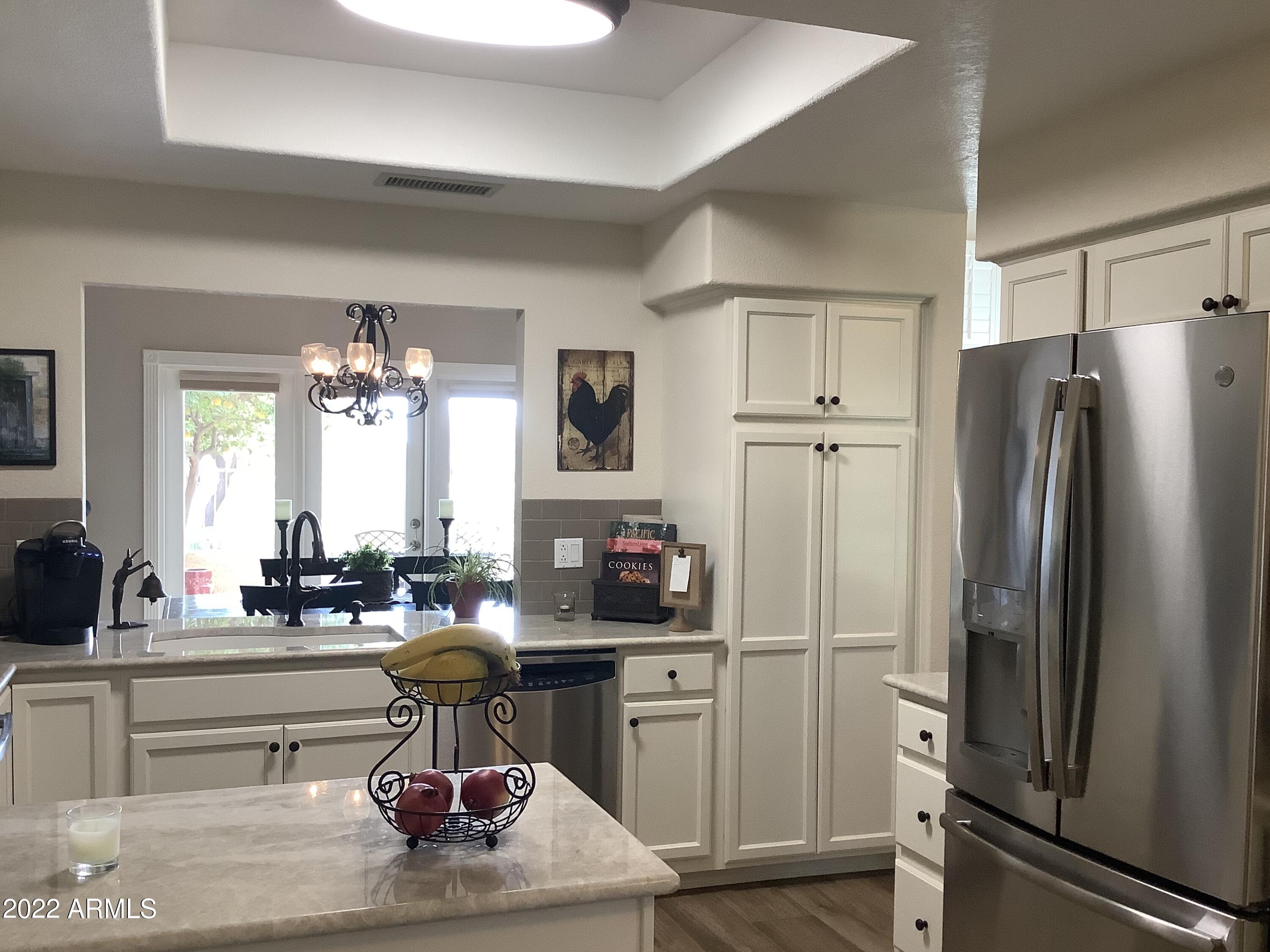 7729 East Joshua Tree Lane Scottsdale, AZ 85250 - Photo 7 of 31 a kitchen with refrigerator and cabinets