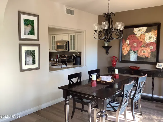 a view of a dining room with furniture a chandelier and wooden floor