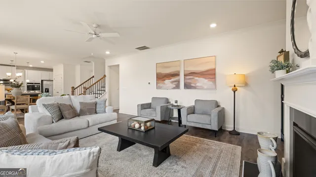 a living room with furniture and paintings on the wall