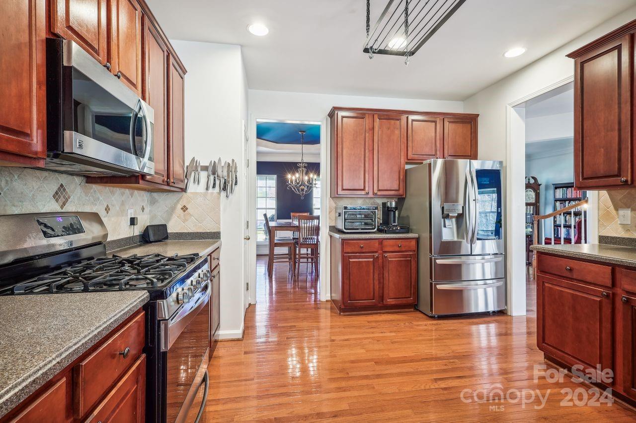 330 Drake Park Avenue Fort Mill, SC 29708 - Photo 10 of 36 a kitchen with stainless steel appliances a refrigerator a stove a sink cabinets and wooden floor