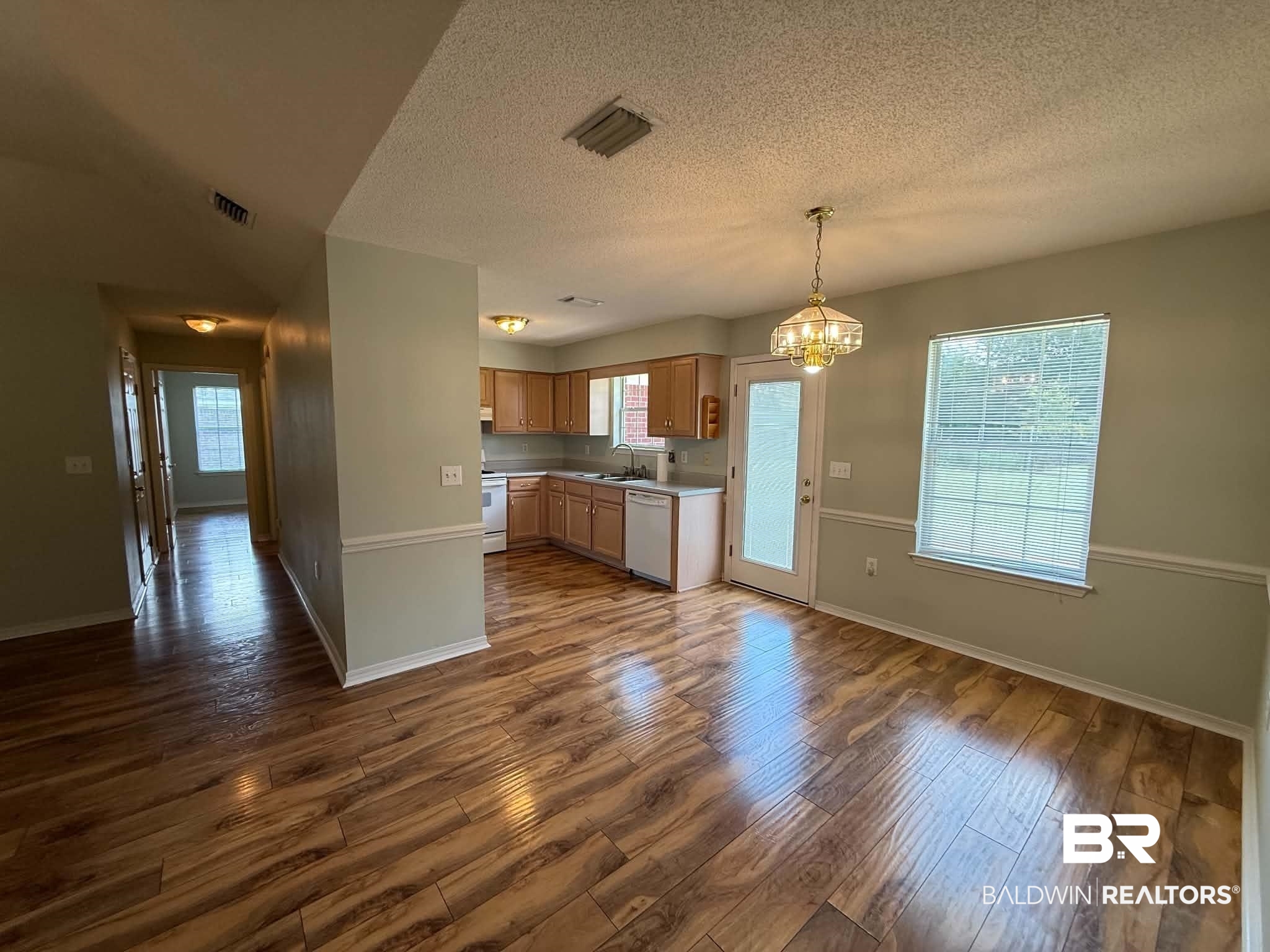 123 Pennbrooke Loop Foley, AL 36535 - Photo 21 of 49 Open-concept kitchen and dining area featuring wood-finish flooring, light oak cabinetry, and white appliances