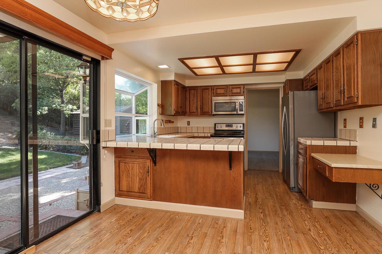 1398 Pierce Ranch Road San Jose, CA 95120 - Photo 6 of 32 a kitchen with stainless steel appliances granite countertop a refrigerator a sink dishwasher a stove and a wooden cabinets with wooden floor