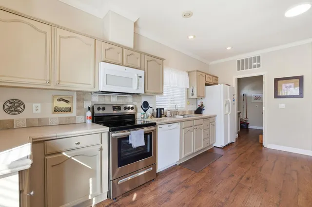 a kitchen with white cabinets and white appliances
