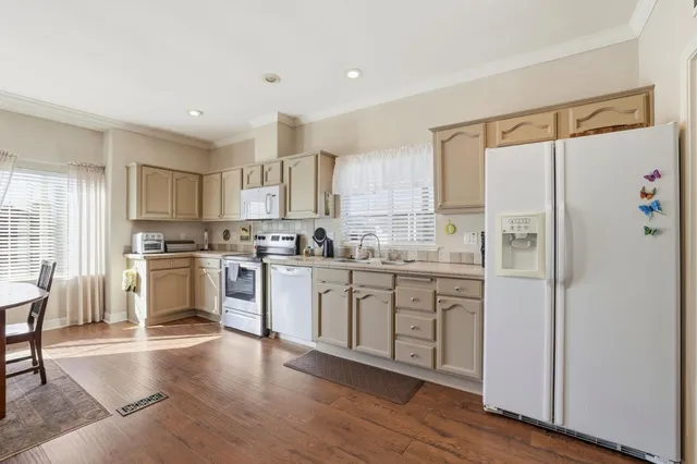 a kitchen with granite countertop cabinets stainless steel appliances and wooden floor