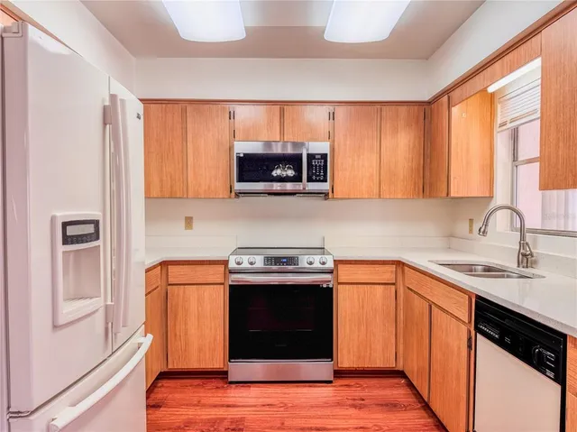 a kitchen with stainless steel appliances granite countertop a stove a sink and a microwave