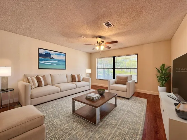 a living room with furniture flat screen tv and a large window