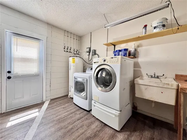 a view of house with wooden fence next to a yard