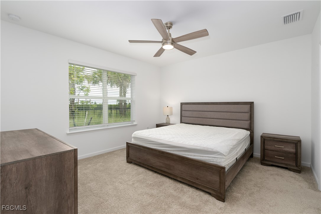 42428 Cascade Drive Punta Gorda, FL 33982 - Photo 19 of 49 a bedroom with a bed a window and a chandelier