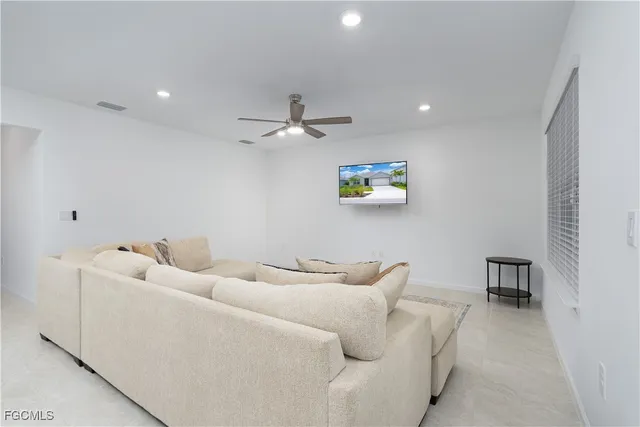 a living room with furniture and a view of kitchen