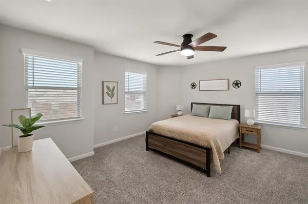 a bedroom with a bed chandelier and a window
