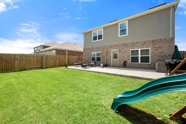 a view of a backyard with a sitting area and a small yard