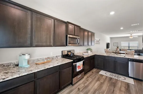 a kitchen with granite countertop cabinets a sink and appliances