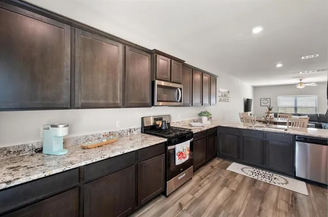 a kitchen with granite countertop cabinets a sink and appliances