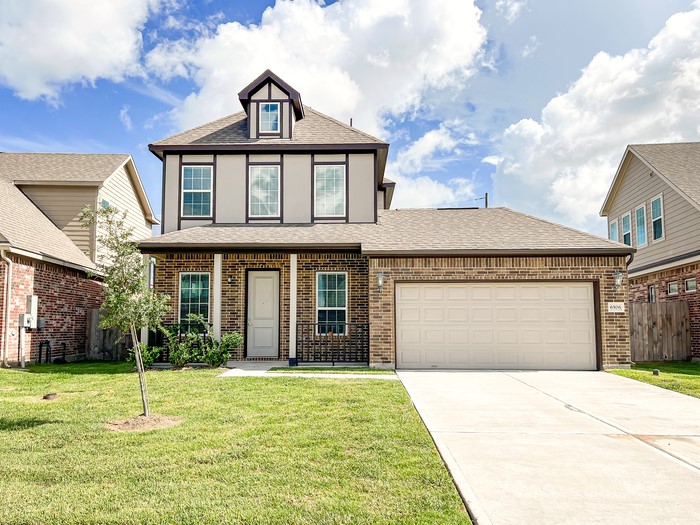 a front view of a house with a yard and garage
