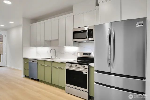 a kitchen with stainless steel appliances a stove microwave and refrigerator