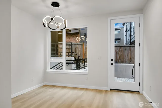 a view of an empty room with wooden floor and windows