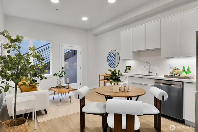 a dining room with furniture a kitchen view and wooden floor