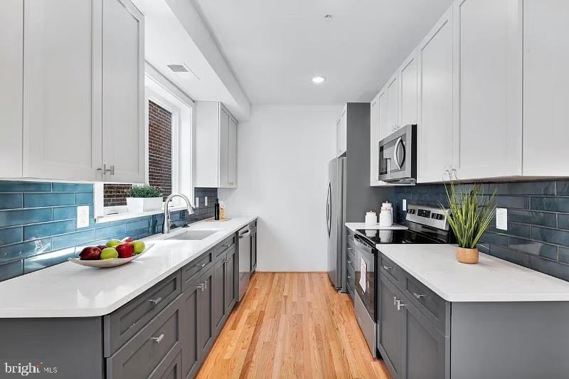 a kitchen with a sink stove top oven and cabinets
