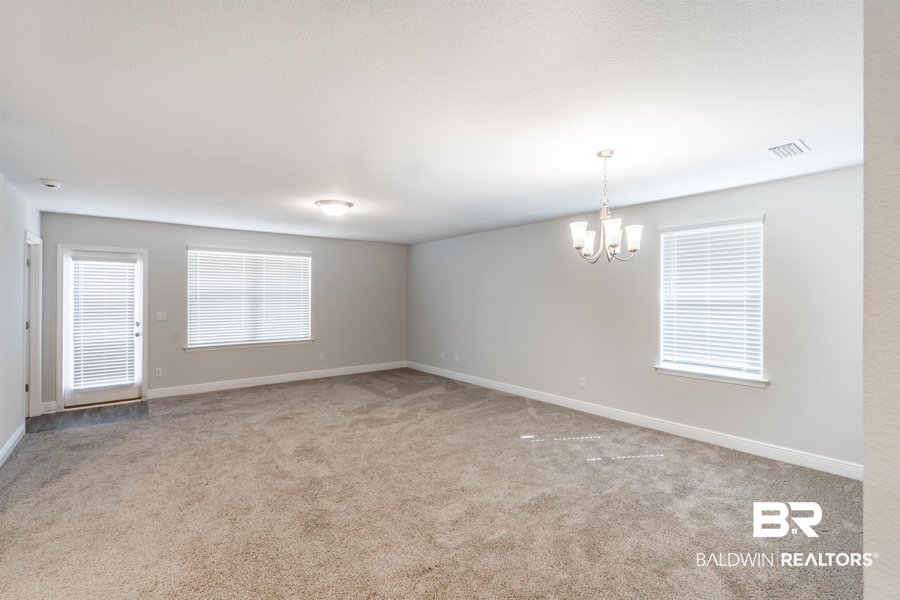 1906 Stonepine Drive South Semmes, AL 36575 - Photo 5 of 30 Empty room featuring light colored carpet and a chandelier