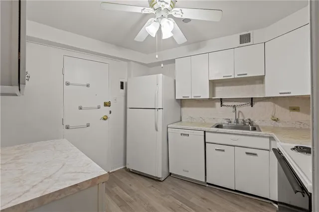 a kitchen with a refrigerator sink and cabinets