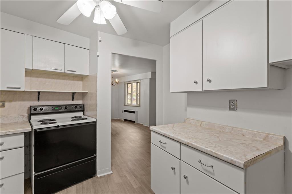 4625 Fifth Avenue, Unit 209 Pittsburgh, PA 15213 - Photo 14 of 23 a kitchen with cabinets appliances and a wooden floor