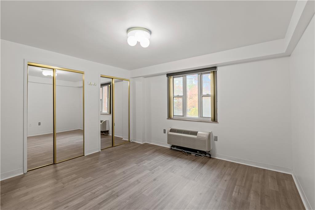 4625 Fifth Avenue, Unit 209 Pittsburgh, PA 15213 - Photo 17 of 23 an empty room with wooden floor and windows