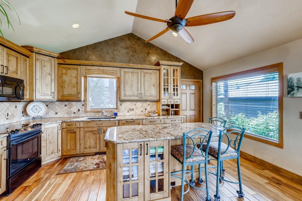 72 Aa Road Silverthorne, CO 80498 - Photo 10 of 28 a open kitchen with stainless steel appliances granite countertop a stove top oven a sink a dining table and chairs with wooden floor
