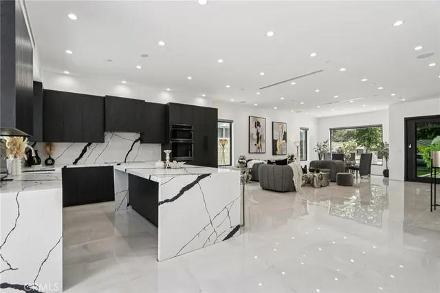 a kitchen with stainless steel appliances kitchen island granite countertop a refrigerator and a stove top oven