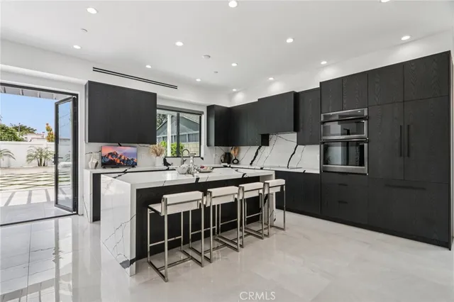 a kitchen with stainless steel appliances kitchen island granite countertop a table and chairs in it