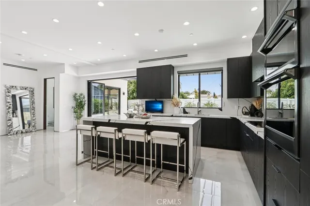 a living room with furniture a flat screen tv and a dining table