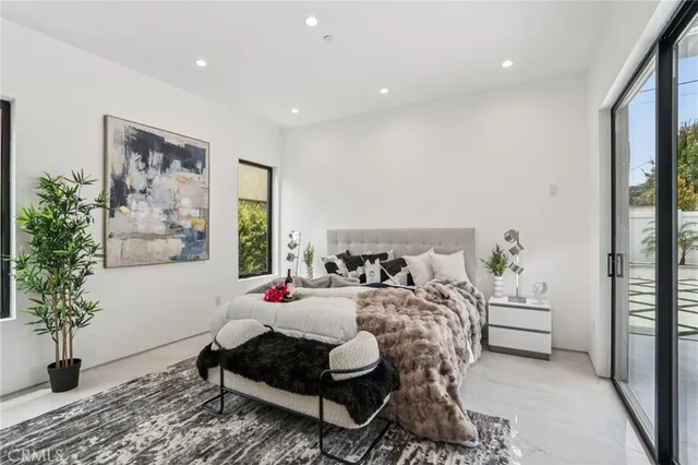 a bedroom with a bed and a large window