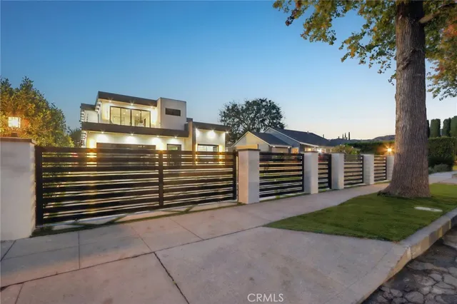a patio with a table and chairs and potted plants