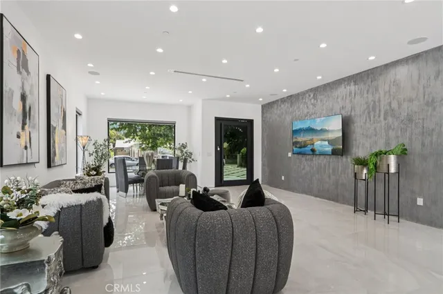a living room with furniture potted plant and a large window