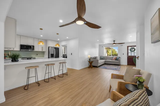 a large white kitchen with lots of counter space dining table and chairs