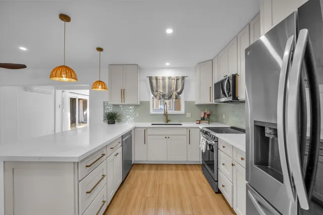 a kitchen with stainless steel appliances a sink stove and refrigerator