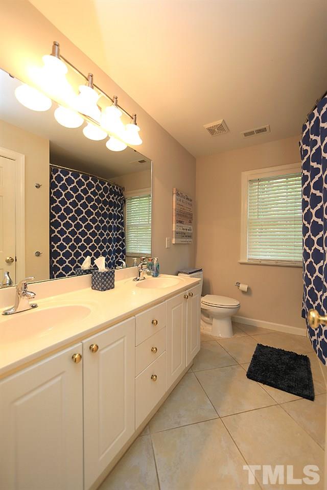 7812 Mayapple Place Raleigh, NC 27613 - Photo 19 of 30 Double sinks, good cabinet storage and a linen closet.