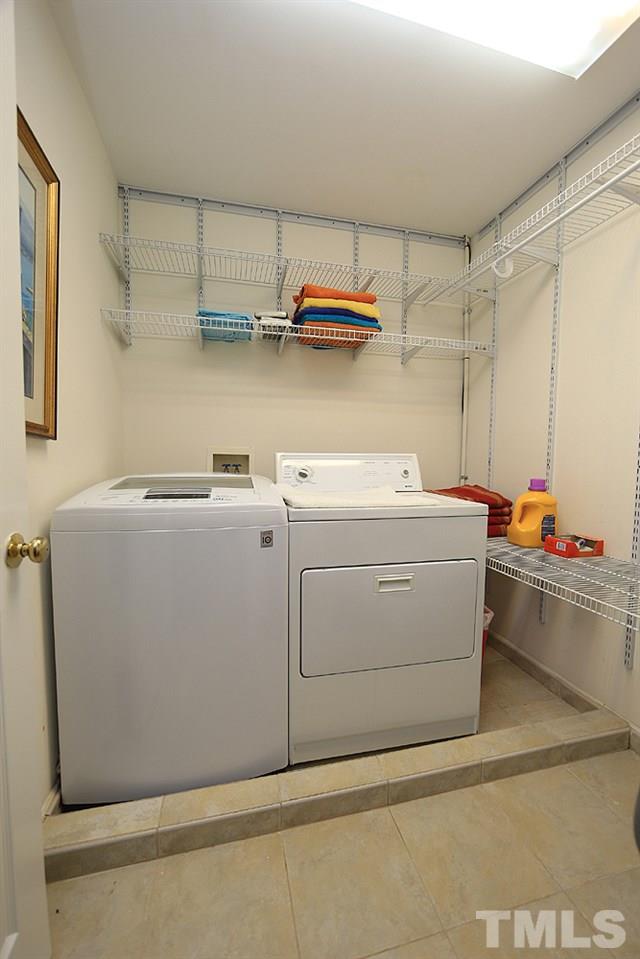 7812 Mayapple Place Raleigh, NC 27613 - Photo 22 of 30 Good storage, shelving in this tile floor laundry room on the second floor.
