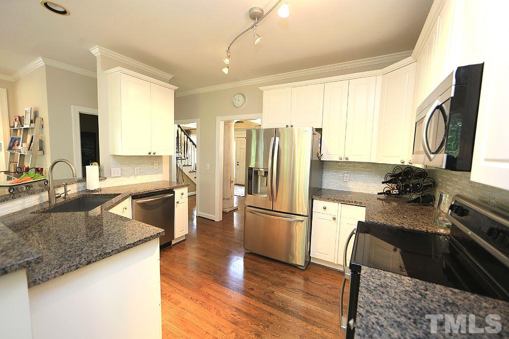 7812 Mayapple Place Raleigh, NC 27613 - Photo 9 of 30 Large sink, SS appliances and granite make this white kitchen an easy place to enjoy.