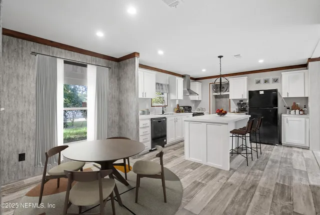a kitchen with a dining table chairs refrigerator and cabinets