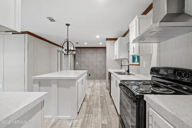 a kitchen with stainless steel appliances a stove a sink and a refrigerator