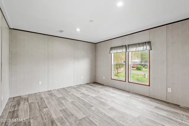 an empty room with windows and closet