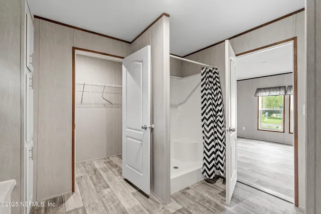a view of a hallway with wooden floor and closet