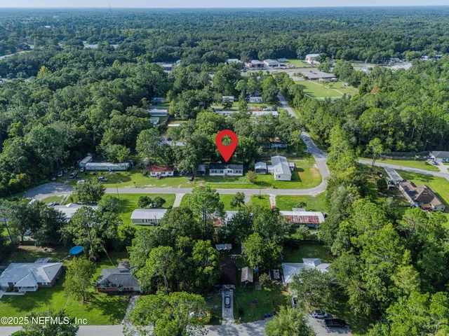 an aerial view of a house with a yard and lake view