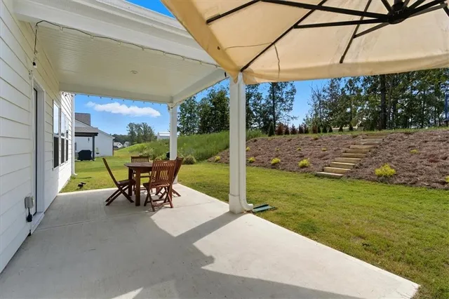 a view of a backyard with table and chairs under an umbrella