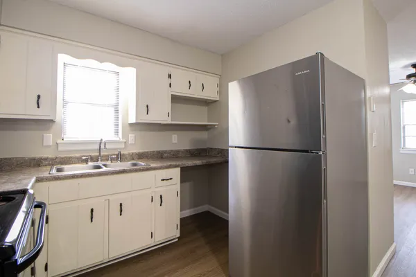 a kitchen with a refrigerator sink and cabinets