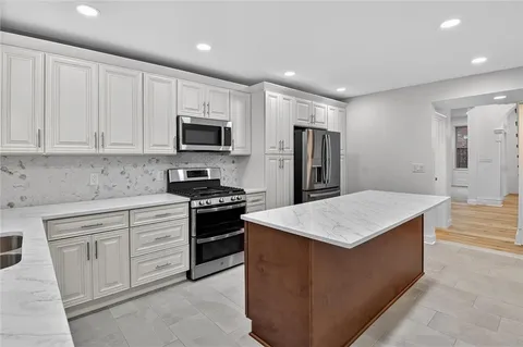 a kitchen with stainless steel appliances granite countertop a stove top oven a sink and dishwasher